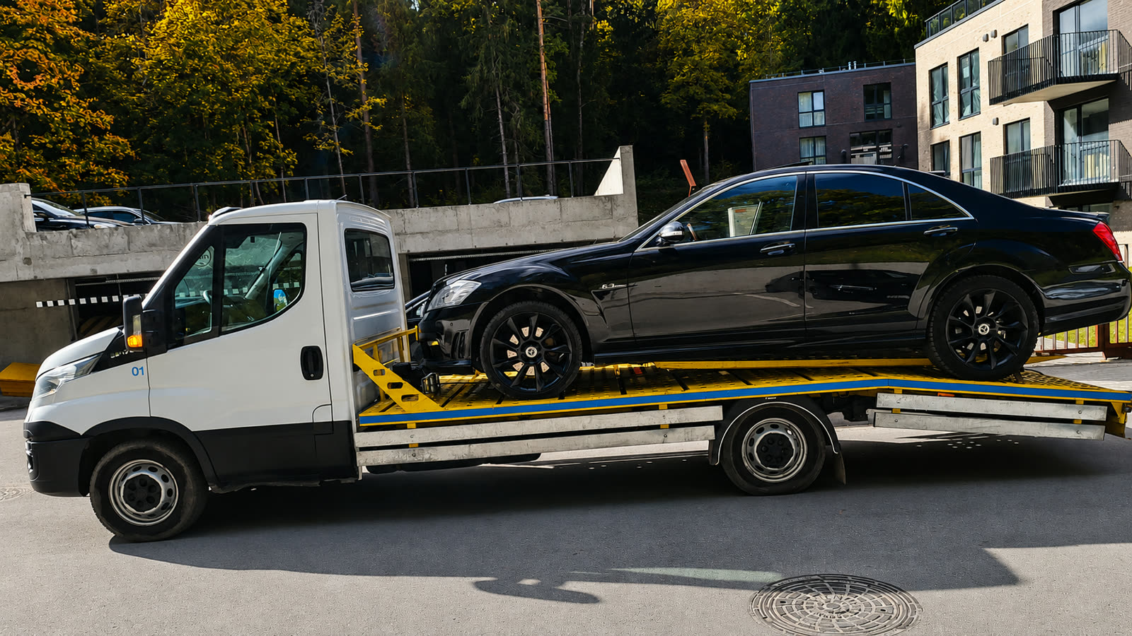 Mūsų tralas Iveco Daily veža juodą sedaną
